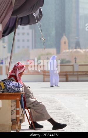 Ein alter Mann, der vor seinem Laden sitzt und auf den Kunden in Doha, Katar wartet Stockfoto