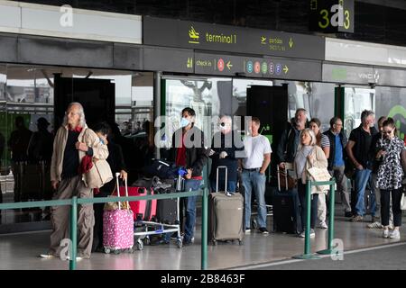 Lissabon, Portugal. März 2020. Passagiere stehen in einer Warteschlange, um das Abflugterminal am Flughafen Humberto Delgado in Lissabon zu betreten.mit der COVID-19-Pandemie, die sich über Europa ausbreitet, hat die portugiesische Regierung die Einstellung von Flügen außerhalb Europas angeordnet. Internationale Flüge von Lissabon nach außerhalb Europas wurden ebenfalls für einen Zeitraum von dreißig Tagen ausgesetzt. Credit: SOPA Images Limited/Alamy Live News Stockfoto