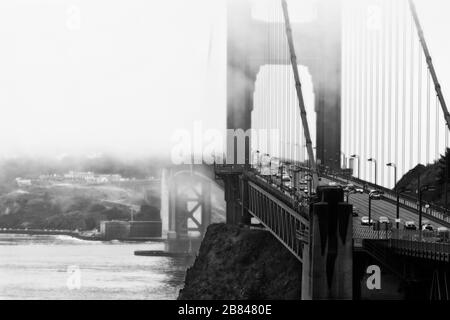 Nebel vor der Bucht umhüllt die Golden Gate Bridge und Presidio, San Francisco, Kalifornien, Vereinigte Staaten, Nordamerika, Schwarzweiß Stockfoto