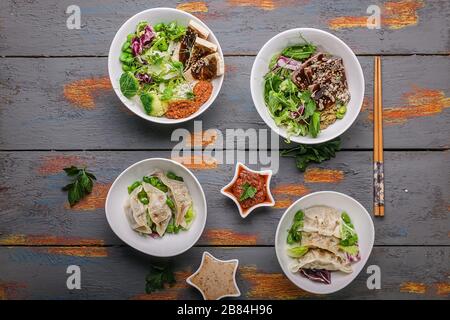 Blick auf traditionelle Gyozu-Knödel, gekochtes Gemüse mit Reis, Schweinefleisch und würziger Soße. Orientalische Küche Stockfoto