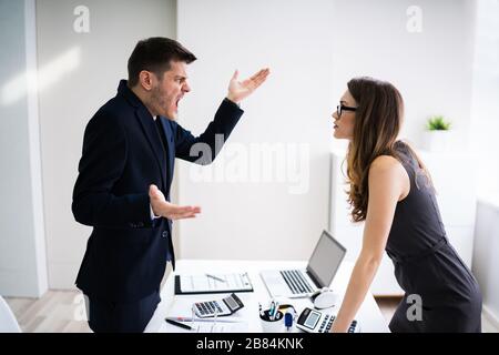 Seitenansicht Der Geschäftsleute, Die Sich Am Schreibtisch Im Büro Zerstritten Stockfoto