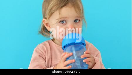 Das Kind trinkt Wasser aus einer Flasche Stockfoto