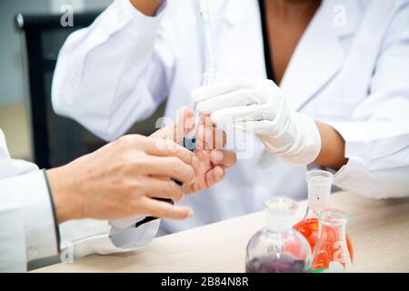 Zwei Wissenschaftler arbeiten im Labor. Junge Forscherinnen und ihre leitende Führungskraft untersuchen Laborgeräte. Stockfoto