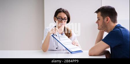 Patient Mit Männlichen Patienten, Der Die Vom Arzt Gehaltenen Testergebnisse Betrachtet Stockfoto