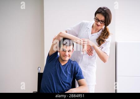 Arzt, Der Die Rehabilitationsübung Für Deaktivierten Patienten Anzeigt Stockfoto