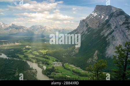 Die Sonne scheint durch die leuchtenden Wolken in einem Tal im Kananaskis Country, Alberta, Kanada Stockfoto