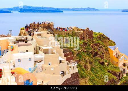 Santorini, Griechenland - 26. April 2019: Stadtpanorama von Oia mit bunten Häusern, Schloss und blauem Meer Stockfoto