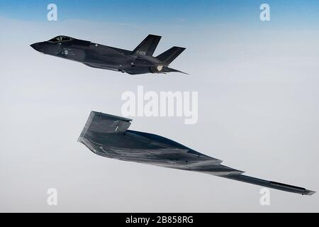 Ein dem 509th Bomb Wing zugewiesener US-amerikanischer B-2A Spirit Bomber und eine Royal Netherlands Air Force F-35A führen Luftoperationen zur Unterstützung der Bomber Task Force Europe 20-2 über der Nordsee durch, 18. März 2020. Bombereinsätze bieten Möglichkeiten, mit NATO-Verbündeten und Theaterpartnern in kombinierten und gemeinsamen Operationen und Übungen zu trainieren und zu arbeiten. (USA Air Force Foto/ Master Sgt. Matthew Plew) Stockfoto