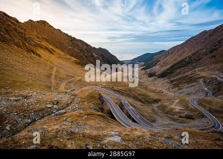 Unglaublicher Blick auf eine einzigartige Straße in den Bergen in einer Höhe von mehr als 2000 m. Vorbeifahrende Autos. Eine der bekanntesten Straßen in Rumänien, Transfagarasan. Stockfoto