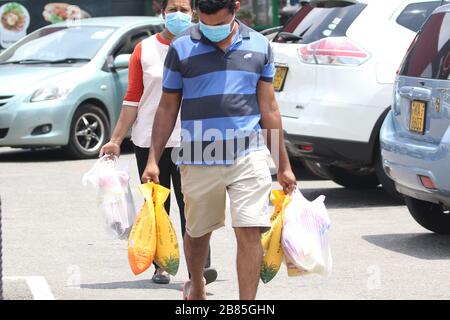 Colombo, Sri Lanka. März 2020. Bürger, die Schutzmasken tragen, fahren am 20. März 2020 aus dem Supermarkt in Colombo. Eine inselweite Ausgangssperre wird heute von 18 Uhr (20) bis 6 Uhr am Montag (23) verhängt, sagt das Präsidentenamt. Kredit: Pradeep Dambarage/ZUMA Wire/Alamy Live News Stockfoto