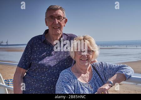 Ältere Paare sehen immer noch gut aus, haben einen Tag am Meer und blicken an einem sonnigen Tag auf den Strand Stockfoto