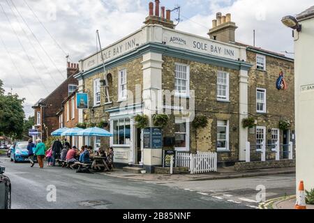 Sole Bay Inn im Sommer, Southwold, Suffolk, Großbritannien; Gäste, die Getränke und Mahlzeiten im Freien genießen. Stockfoto