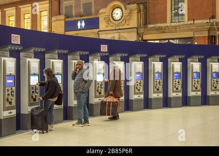 Bahnreisende kaufen nachts Zugtickets an Automaten, Victoria Bahnhof, London UK. Londoner Transport, Bahnfahrt, Fahrkartenautomat. Stockfoto