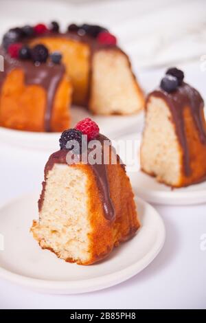 Zwei Teller mit einer Scheibe leckerer hausgemachter Vanillegebäckchen mit Beeren Stockfoto