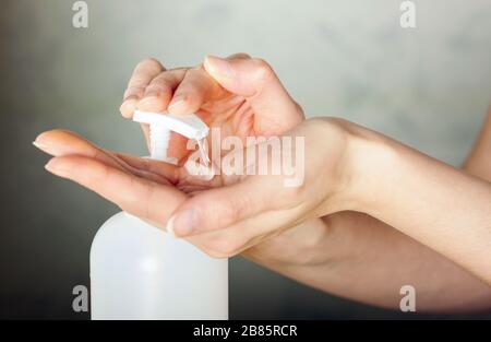 Halten Sie antiseptisches antibakterielles Desinfektionsmittel in der Hand, das im Hintergrund isoliert ist. Schutz vor Coronavirus Stockfoto