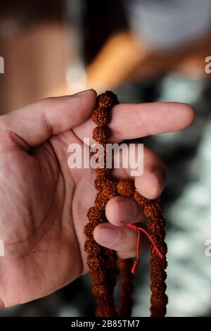 Hand des Betens, die Rudraksha-Perlen oder Rosary hält