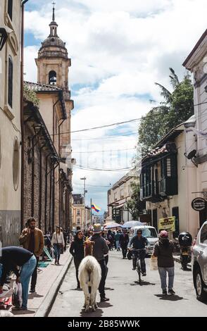 Hektik in einer der geschäftigsten Straßen, die zur Plaza Bolivar in der Altstadt von La Candelaria in Bogota, Kolumbien führt Stockfoto