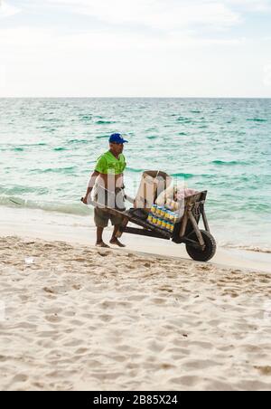 Der lokale kolumbianische Händler verkauft Getränke in Dosen aus seiner Schubkarre am Strand von Isla Baru, in der Nähe von Cartagena, Kolumbien Stockfoto