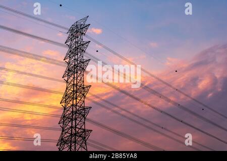 Grüne Energie Konzept, Strom Bahnhof, in der Nähe von Hochspannungsleitungen bei Sonnenuntergang. die Verteilung von Strom entfernt. Hochspannung elektrische Geber für Getriebedrehzahl Stockfoto