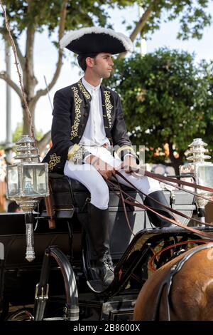 Elegante Pferdekarruage in traditioneller Kleidung auf der Aprilmesse (Feria de Abril), Messe Sevilla Stockfoto