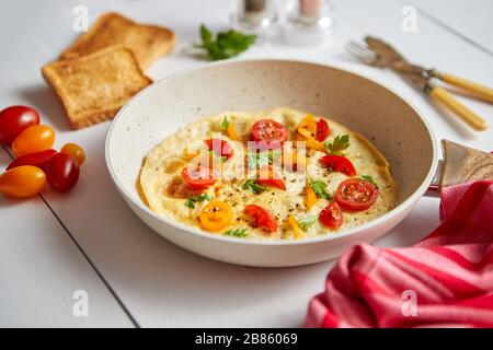 Leckere hausgemachte klassische Omelett mit Kirschtomaten Stockfoto