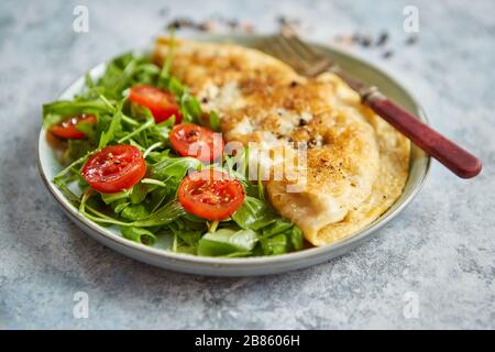 Klassische ei Omelette mit Cherry Tomaten und Rucola Salat auf Seite Stockfoto