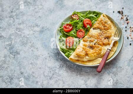 Klassische ei Omelette mit Cherry Tomaten und Rucola Salat auf Seite Stockfoto