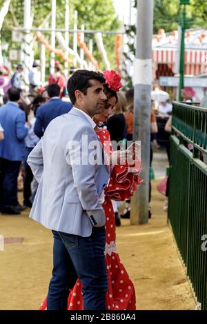 Junges schönes Paar, das auf der Aprilmesse (Feria de Abril), der Messe Sevilla (Feria de Sevilla), Andalusien, Spanien, genießt Stockfoto