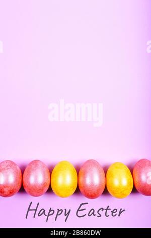 Ostereier in gelben und pinkfarbenen Farben auf pinkfarbenem Hintergrund gemalt. Frohe Ostern Stockfoto