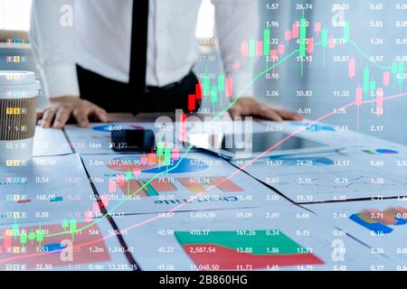 Unternehmer planen, in die Börse zu investieren. Indem die Analysetabelle dokumentiert wird, die auf dem Schreibtisch platziert werden soll, um Nachteile zu prüfen, solutio Stockfoto