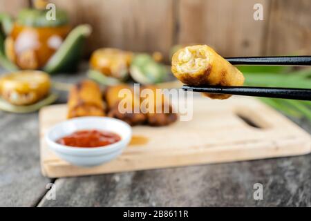 Frühlingsrollen stammen aus dem chinesischen, die wir im Menü Dim Sum gegessen haben. Die ursprüngliche Füllung ist Hackfleisch Schweinefleisch vermicelli. Essstäbchen spannen ihn. Stockfoto