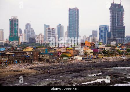 Blick auf das Dorf der Fischer von Mumbai mit modernen Glas- und Stahltürmen auf dem Hintergrund Stockfoto