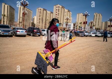 (200320) -- KUNMING, 20. März 2020 (Xinhua) -- der Villager Wang Daxiang geht auf ihr neues Haus zu, nachdem er Bedarf im Umsiedlungsgebiet von Maojiawan im Kreis Ludian, im Südwesten Chinas Provinz Yunnan, am 15. März 2020 gekauft hat. Das Dorf Luoqiu liegt tief in den Bergen der südwestchinesischen Provinz Yunnan und beherbergt nur Dutzende von Haushalten, die sich im Tal der Berge verstreut haben. Der Dorfbewohner Yan Fugao und seine Frau Wang Daxiang leben seit mehr als 20 Jahren hier. Die raue Berglandschaft hier hat die wirtschaftlichen Aktivitäten der Einheimischen stark eingeschränkt und einige von ihnen arm gemacht. Yan Fugaos Familie Stockfoto