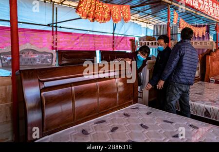 (200320) -- KUNMING, 20. März 2020 (Xinhua) -- der Villager Wang Daxiang (L) und ihr Ehemann Yan Fugao wählen Bett für ihr neues Haus im Maojiawan Umsiedlungsgebiet im Ludian County im Südwesten Chinas Yunnan Provinz, 15. März 2020. Das Dorf Luoqiu liegt tief in den Bergen der südwestchinesischen Provinz Yunnan und beherbergt nur Dutzende von Haushalten, die sich im Tal der Berge verstreut haben. Der Dorfbewohner Yan Fugao und seine Frau Wang Daxiang leben seit mehr als 20 Jahren hier. Die raue Berglandschaft hier hat die wirtschaftlichen Aktivitäten der Einheimischen stark eingeschränkt und einige von ihnen arm gemacht. Yan Fugao' Stockfoto