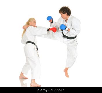 Junge Karateka-Schüler in weißen Kimono-Schwarzgurten im Kampfhandschuhzug trainieren Schläge mit Tritten und Händen auf weißem Hintergrund. Professiona Stockfoto