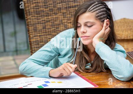 Schöne müde Mädchen-Studentin, die ihre Hausaufgaben mit Konzentration macht Stockfoto