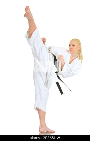 Junge talentierte blonde Profi-Karate-Athletin im Kimono-Anzug mit schwarzem Gürtel zeigt einen tritt und einen guten Stretch auf weißem Hintergrund. Adver Stockfoto