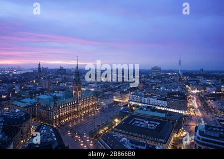 Luftbild der Skyline von Hamburg, Deutschland am Abend. Blick auf das Hamburger Rathaus und die beleuchteten Gebäude Stockfoto