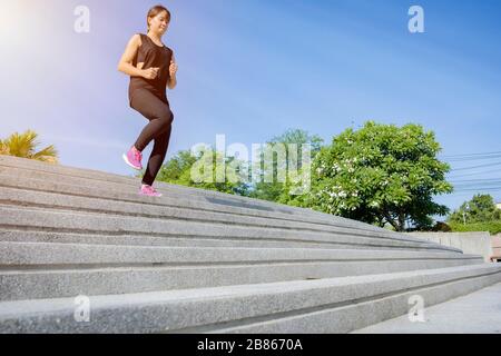 Fitness Sport Konzept, Frau in der Mode Sportbekleidung, Fitness Übung in der Stadt Straße über grauer Beton Hintergrund. Outdoor Sport Kleidung ein Stockfoto