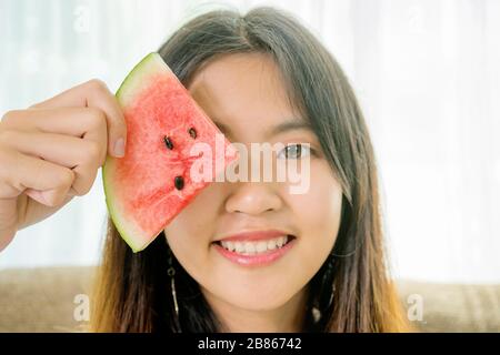 Asiatische Frauen essen Wassermelone, um sich in der heißen Atmosphäre zu erfrischen. Stockfoto