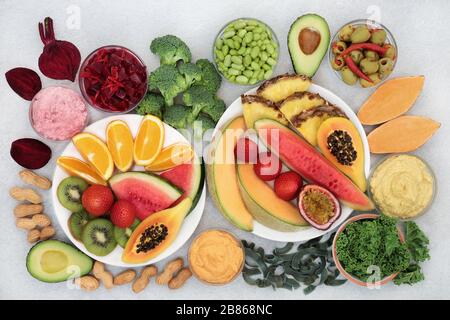 Vegane Gesundheitsnahrung für Vitalität und Fitness mit Obst, Gemüse, Pasta, Hülsenfrüchte und Nüssen. Hoch an Vitaminen, Mineralstoffen, Antioxidantien und Proteinen. Stockfoto