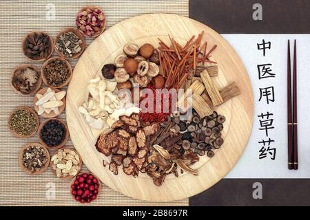 Chinesische Kräuter mit Kalligraphie-Schrift auf Reispapier mit Übersetzungslesen als traditionelle chinesische Kräuter, die in der Kräutermedizin verwendet werden. Stockfoto