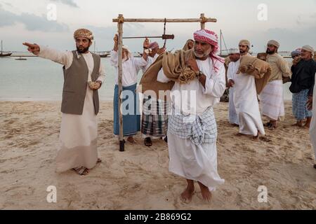 Traditionelle arabische Fischer arbeiten in Katara Strand Doha, Katar mit Daus im Wasser und Wolken am Himmel im Hintergrund. Stockfoto
