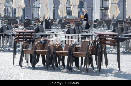 Augsburg, Deutschland. März 2020. Auf dem Rathausplatz am späten Morgen sind die Stühle der Straßencafés nur spärlich besetzt. Kredit: Stefan Puchner / dpa / Alamy Live News Stockfoto