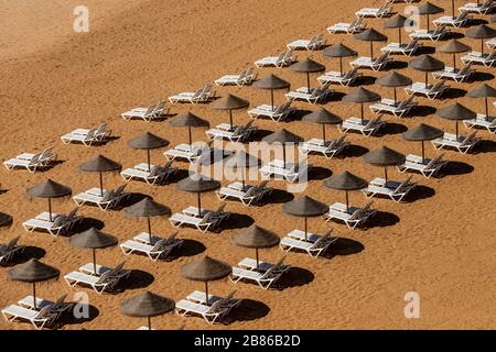 Sonnenliegen und weiße Wolken in Albufeira, Portugal Stockfoto