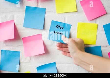 Hand bleiben Sie zu Hause Wörter in farbigen Notizen Stockfoto