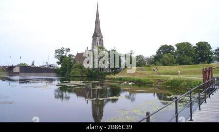 KOPENHAGEN, DÄNEMARK - 4. Jul. 2015: St. Alban's Anglican Church und ein Spiegelbild im Wasser während eines Sonnenuntergangs Stockfoto