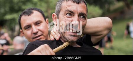 Filipino escrima arnis Instruktor und Student Practice Stick Fight Choke Techniken auf dem Kapap Martial Arts Seminar Stockfoto