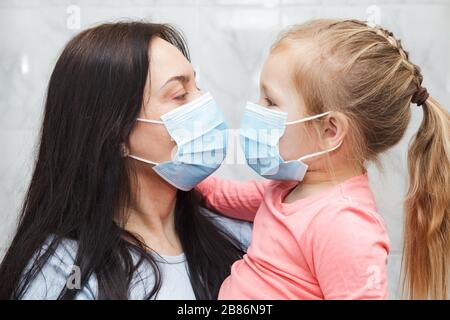 Frau und Mädchen tragen medizinische Masken. Stockfoto