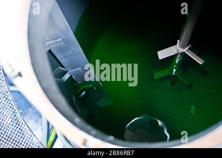 Reinigen Sie das Produkt in einen großen Aluminiumbehälter, der in Flaschen abgefüllt werden kann Stockfoto